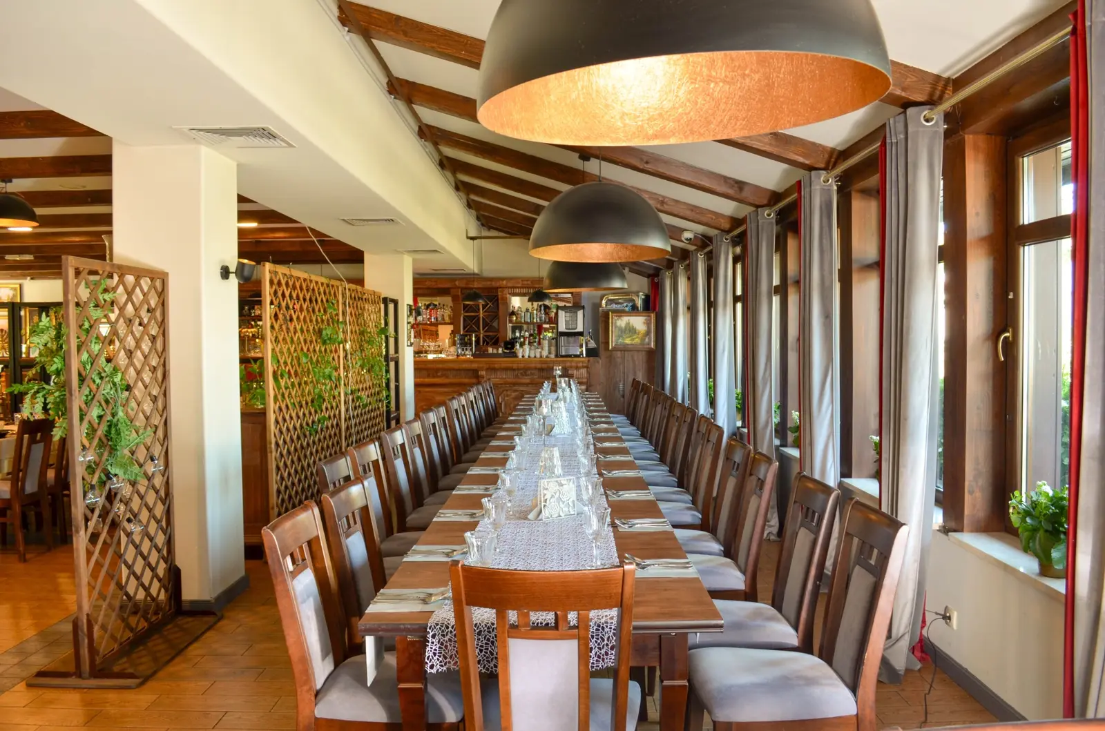 Sala Restauracji U Jakuba z nakrytym stołem wzdłuż okien